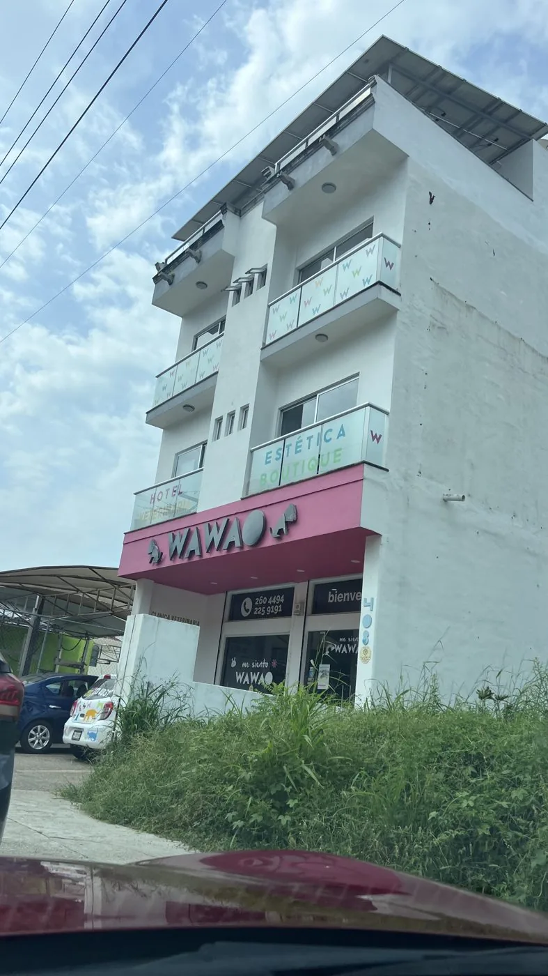 El edificio de cuatro pisos de Wawao visto desde la calle, con la marquesina rosa